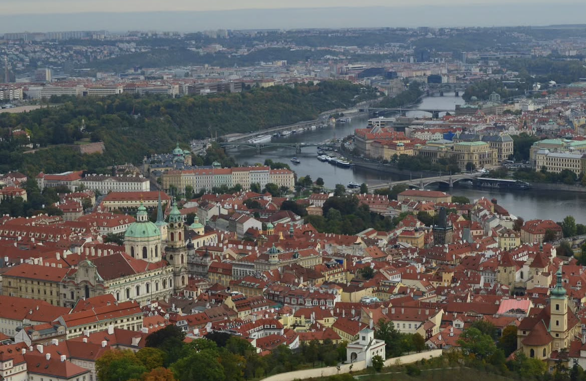 Panorámica de la ciudad de Praga desde un mirador, con el río Moldava y sus puentes al amanecer.