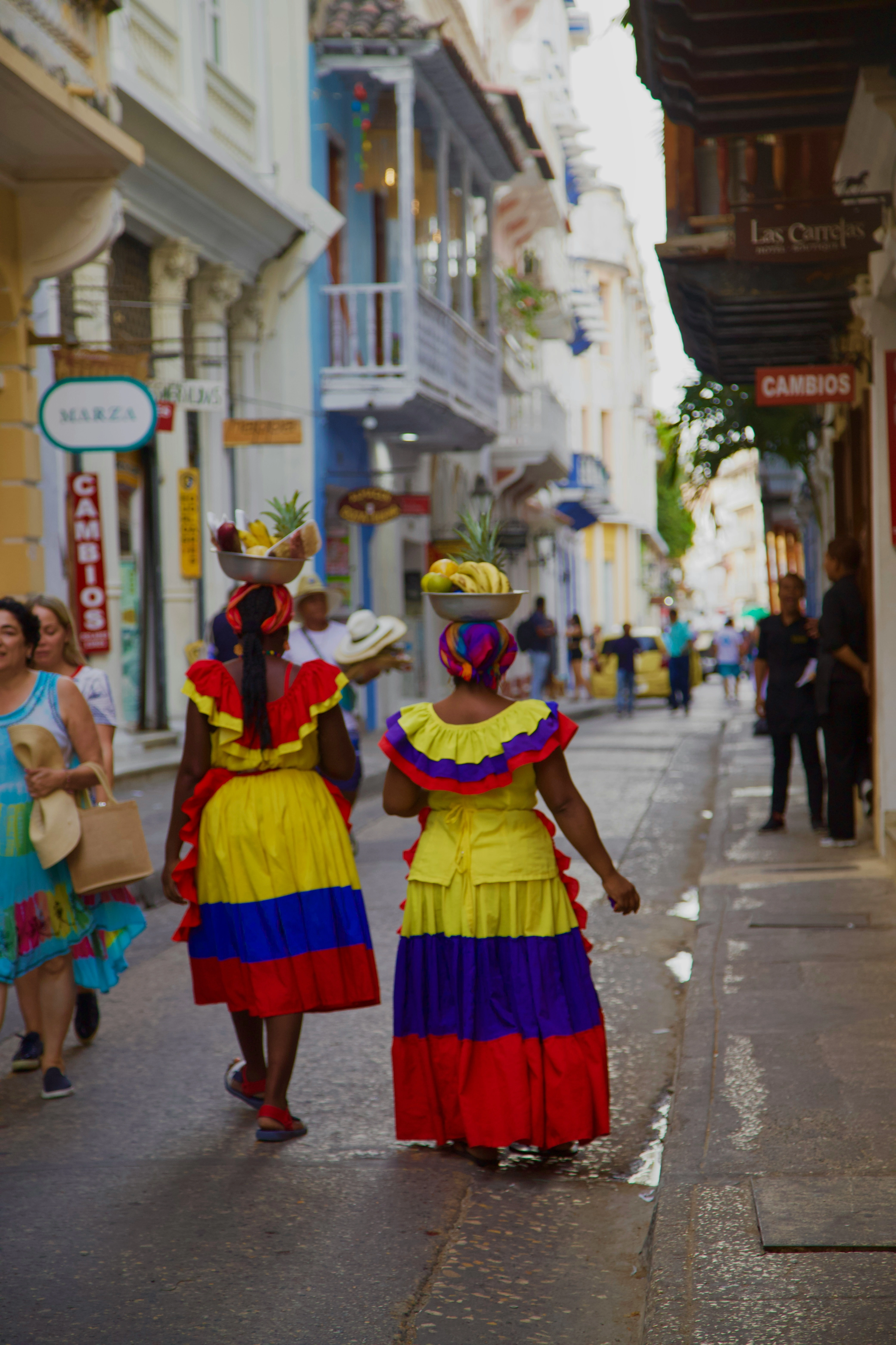 Dos mujeres colombianas con vestidos típicos caminando por las calles de Cartagena