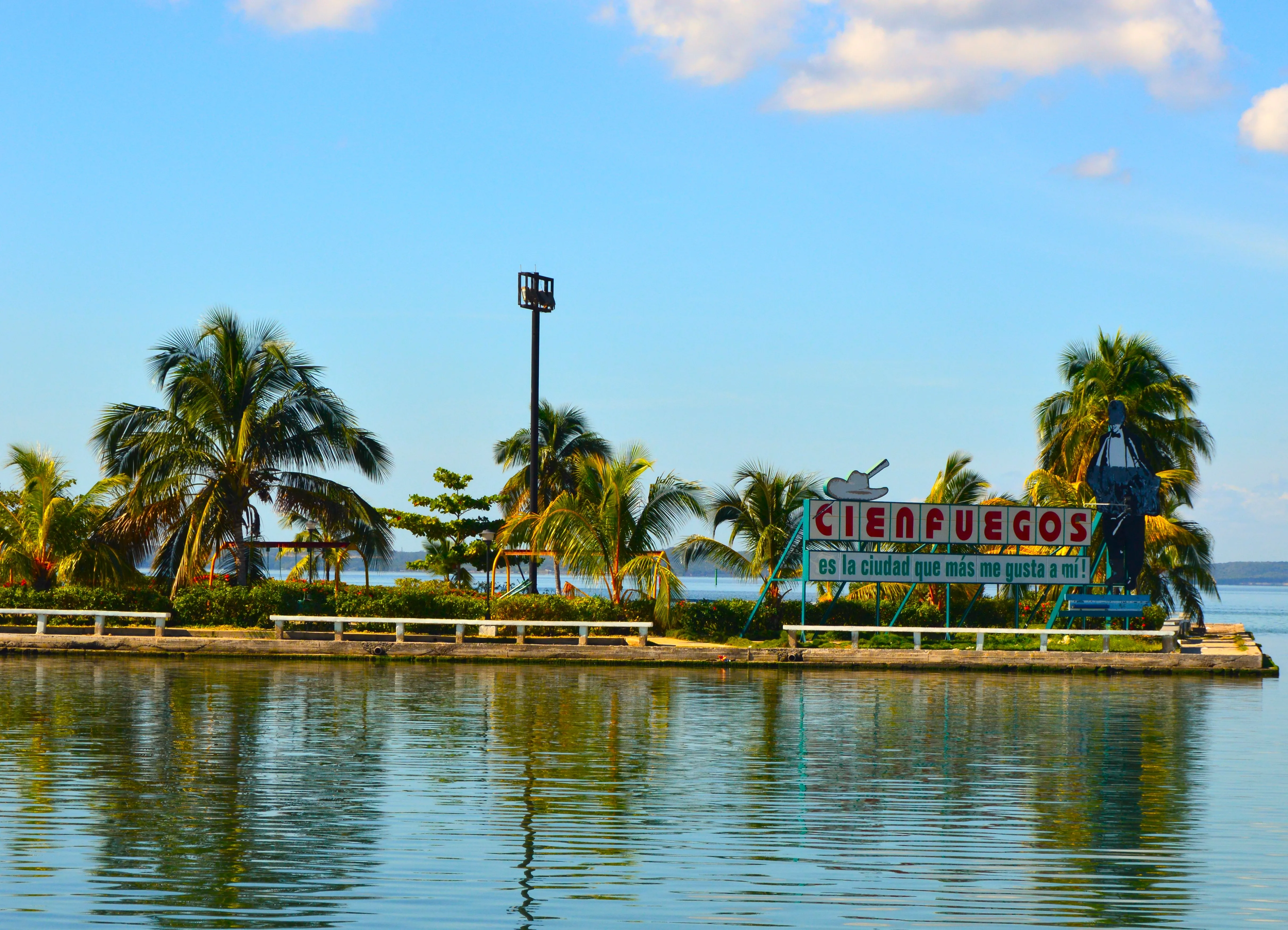 Cartel de bienvenida a Cienfuegos junto a la bahía con vista al agua