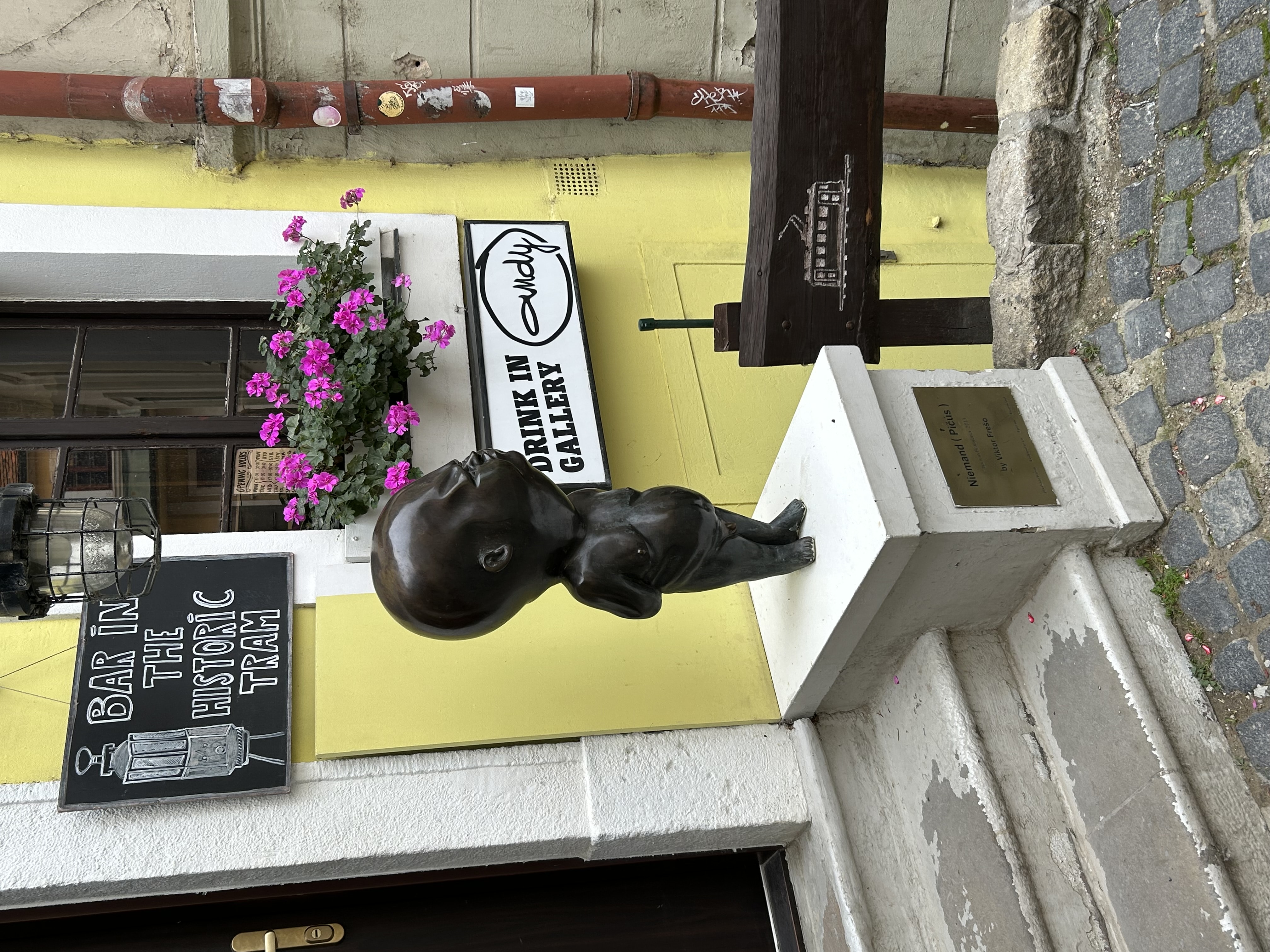 Escultura de hombre calvo con panza en un bar de Bratislava