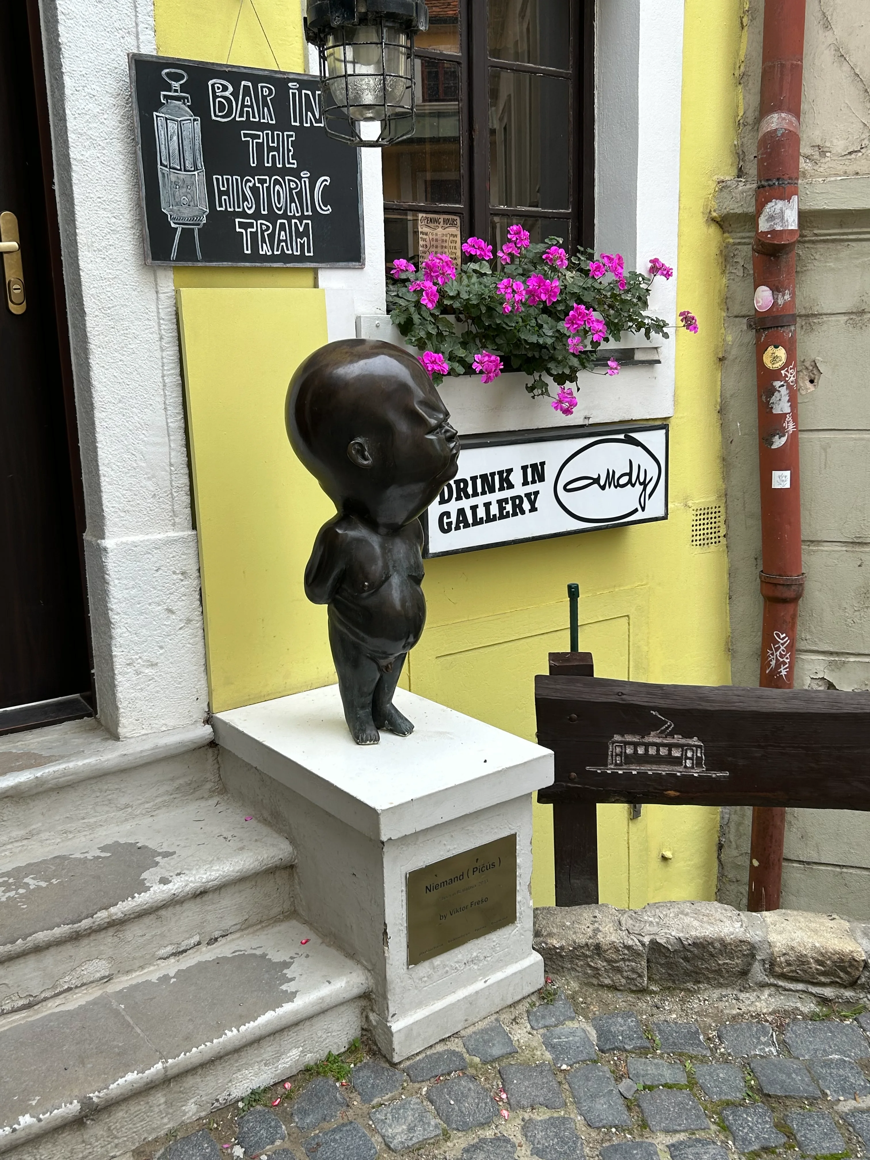 Escultura de hombre calvo con panza en un bar de Bratislava