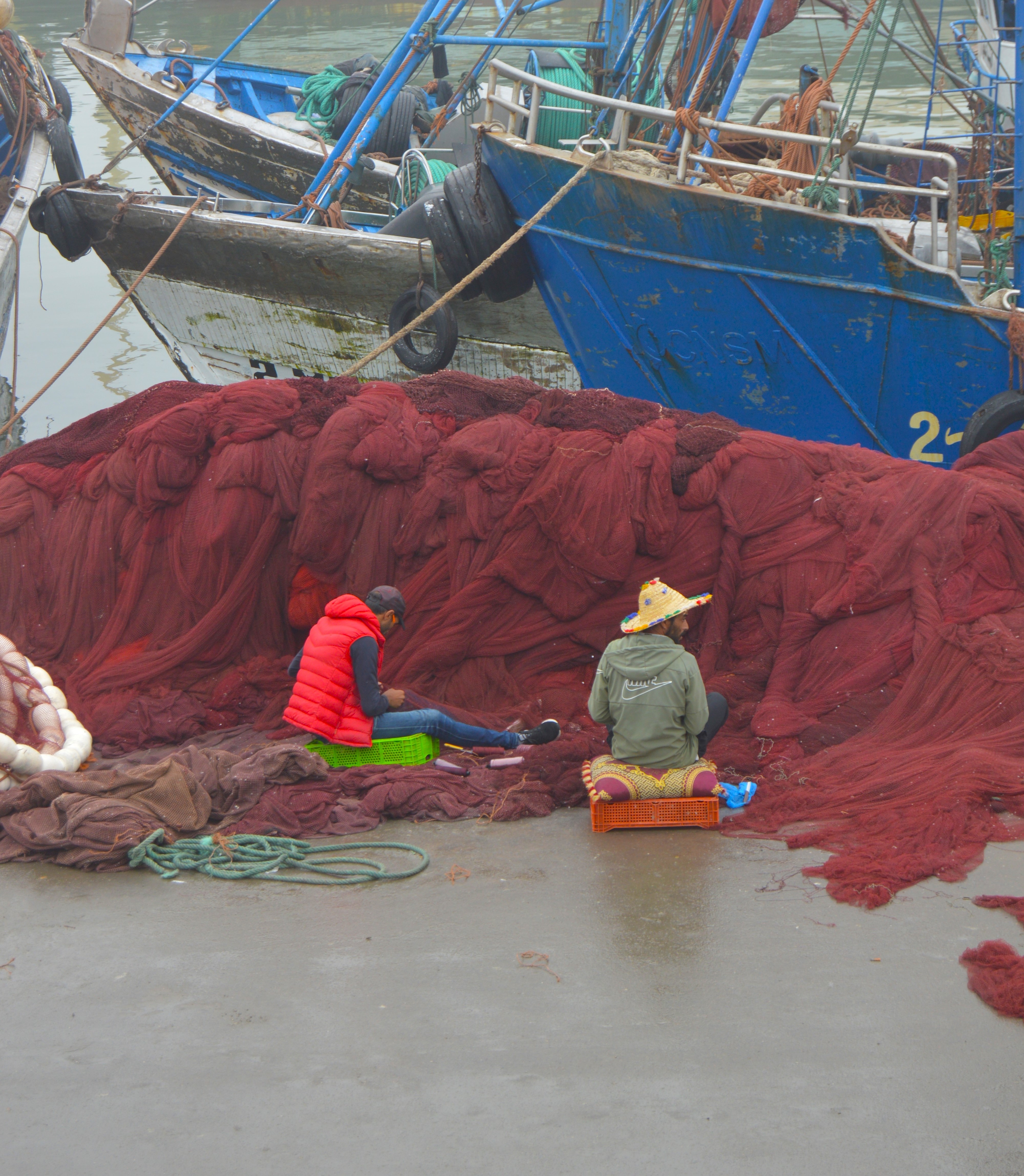 Pescadores reparando redes en el puerto de Essaouira - Trabajo tradicional marroquí
