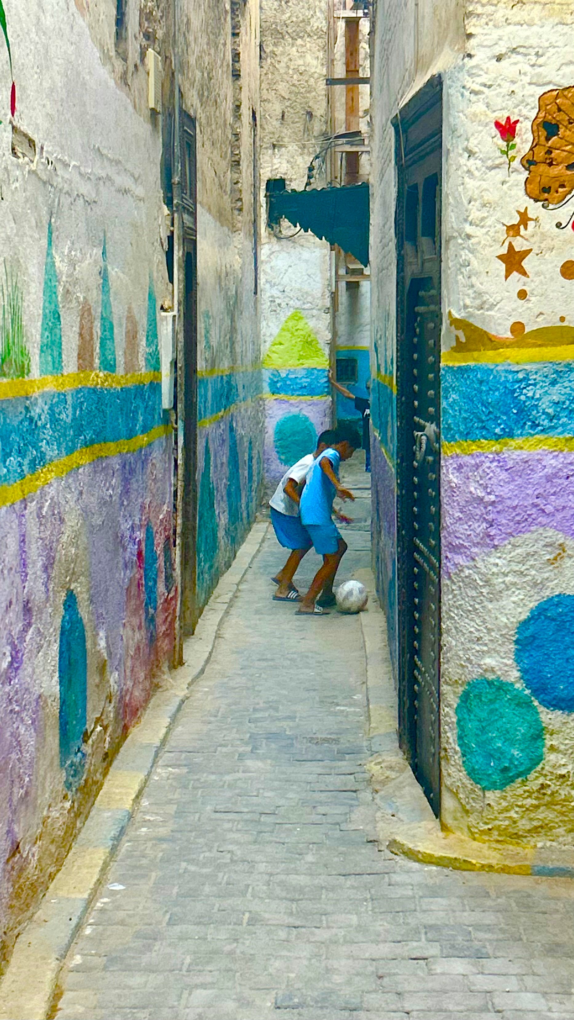 Dos niños jugando fútbol en un callejón de la Medina de Fez
