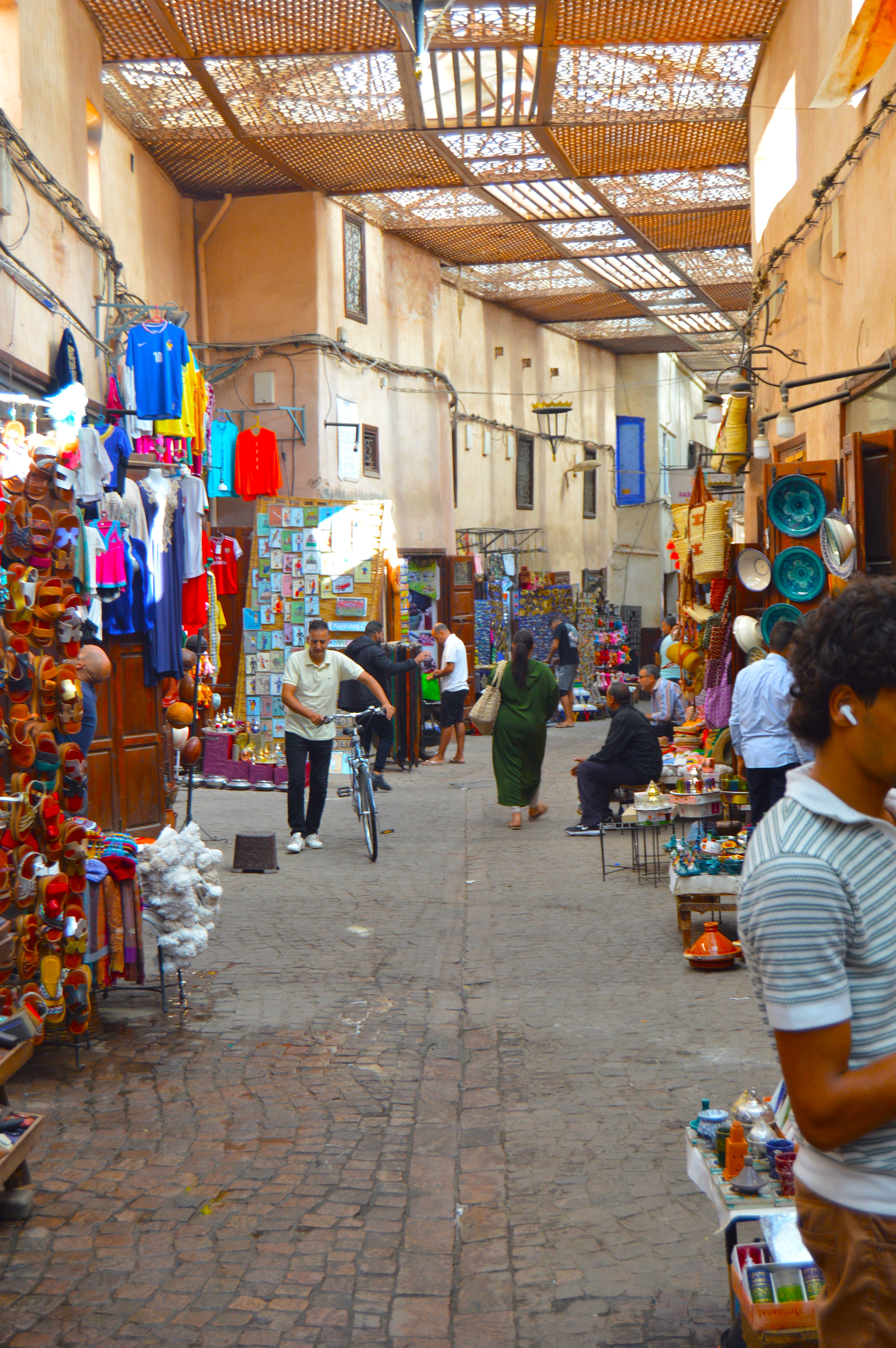 Escena cotidiana en la Medina de Marrakech - Personas caminando entre puestos de mercado