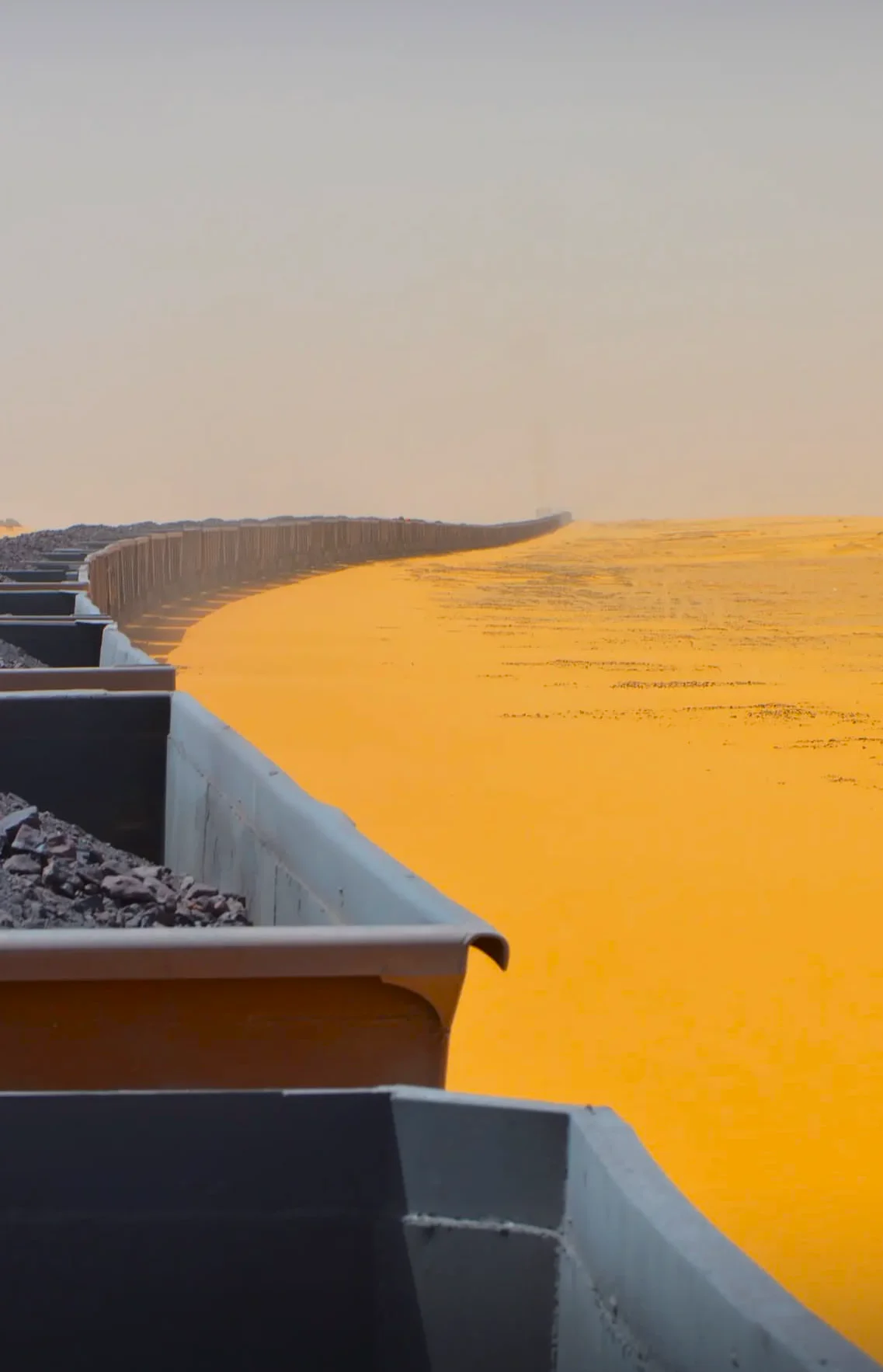 Tren de Hierro de Mauritania cruzando el desierto del Sáhara con polvo de mineral y sol abrasador