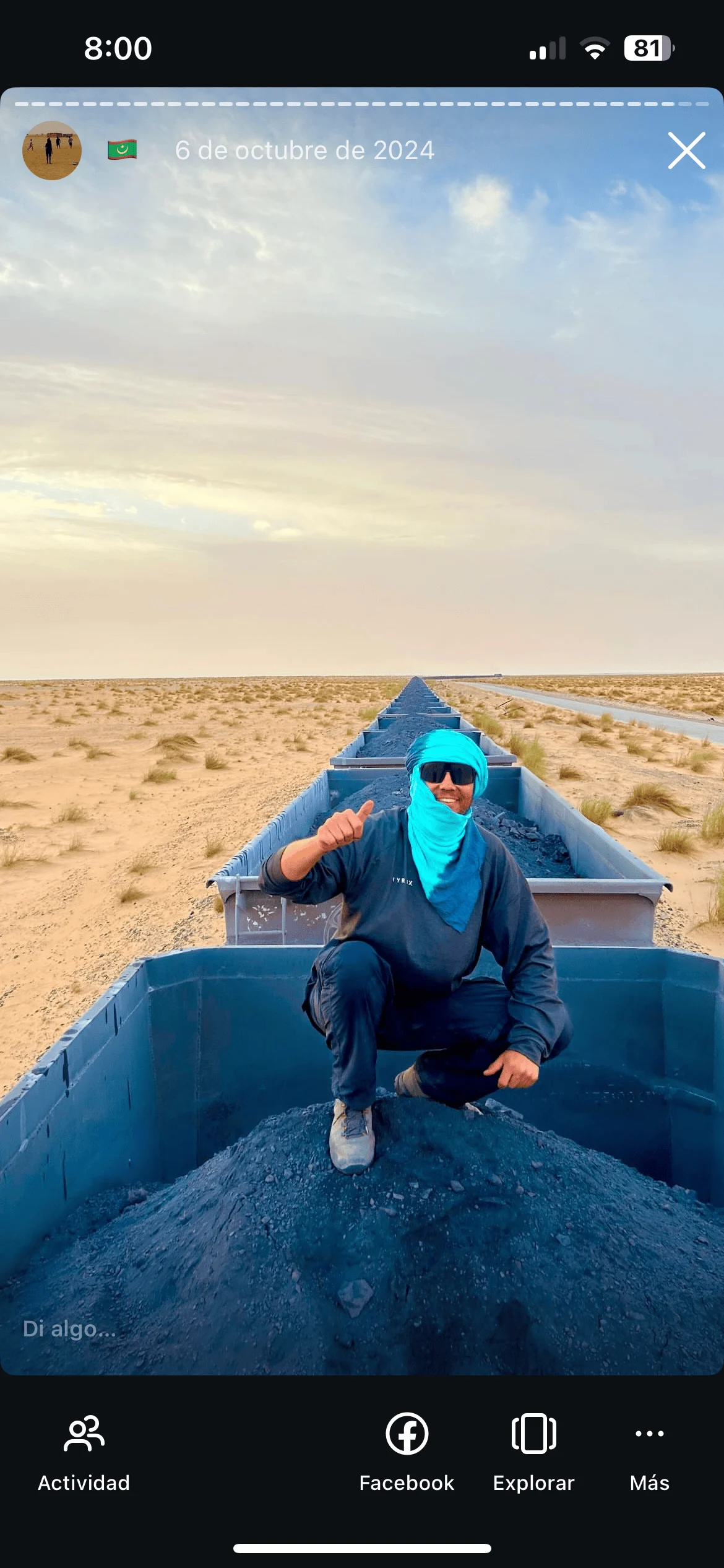 Persona sobre el Tren de Hierro con vagones cargados de mineral y el desierto del Sáhara de fondo