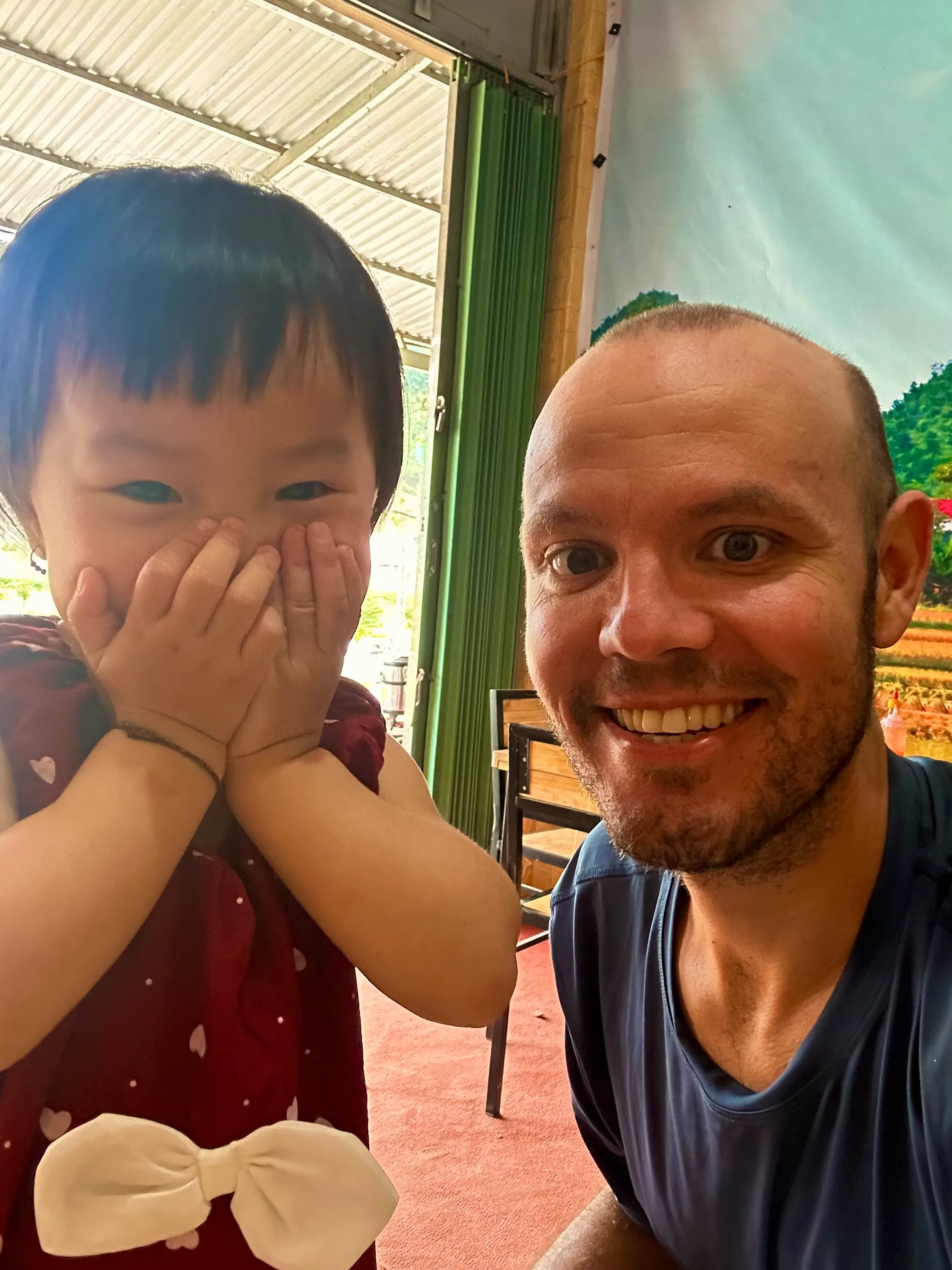 Na, una niña local sonriente junto al camino